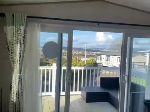 Sliding doors from the lounge open onto the decking, with outdoor seating and views across Paignton